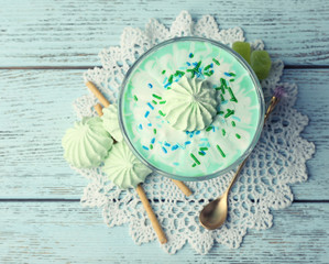 Mint milk dessert in glass bowl on color wooden background