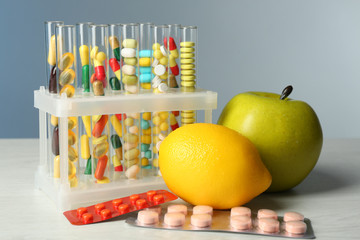 Different color drugs in test tubes and fruit,