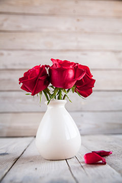 Red Rose In Vase On Wooden Table