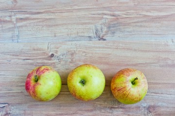 Three apples at wooden background