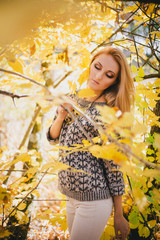 Beautiful young woman posing in an autumn forest