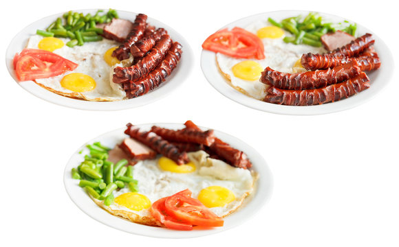 three plates with fried eggs and sausages isolated
