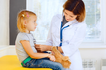 Pediatrician doctor examining little girl.