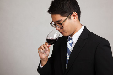 Asian businessman smell aroma of  red wine