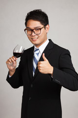 Asian businessman thumbs up with glass of red wine