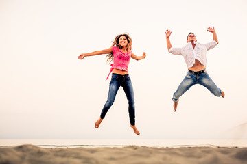 Fototapeta na wymiar Happy Couple jumping on the beach