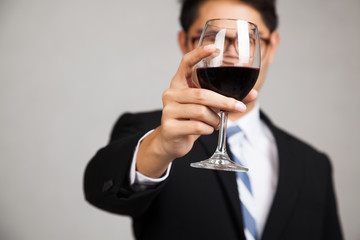 Asian businessman with glass of red wine focus at glass