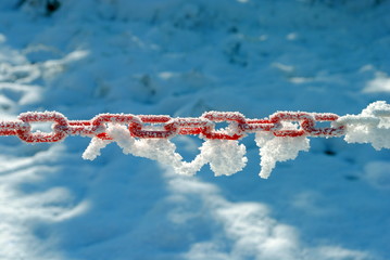 red and white plastic chain covered by snow