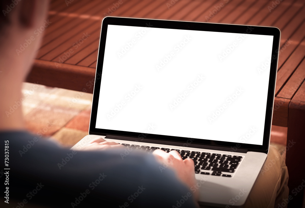 Aufkleber man using notebook with blank screen while sitting on sofa.