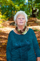 Seniorin enjoys the outdoors in autumn park