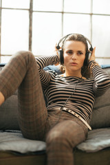 Obraz premium Portrait of young woman listening music in headphones 
