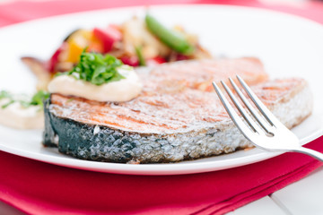 Grilled Salmon with Fresh vegetables on red background