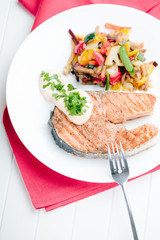 Grilled Salmon with Fresh vegetables on red background