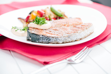 Grilled Salmon with Fresh vegetables on red background