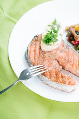 Grilled Salmon with Fresh vegetables on green background