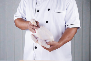 Chef holding the raw chicken