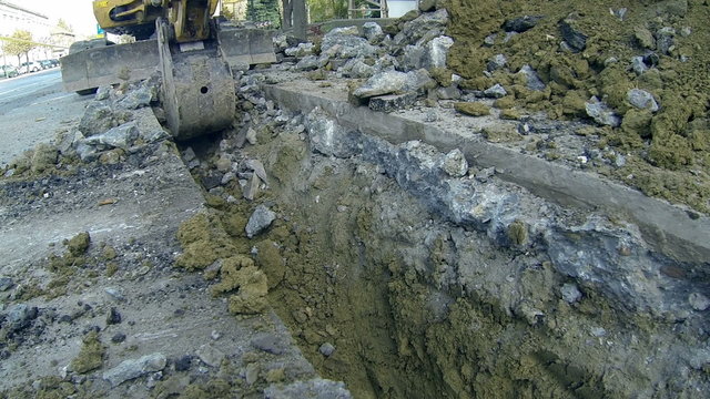 Excavator Digging a Trench on City Streets