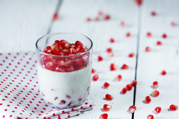 Delicious dessert pannacotta with fresh pomegranate seeds in a g
