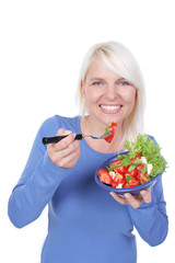 Hübsche blonde Frau isst Tomatensalat mit Mozarrella