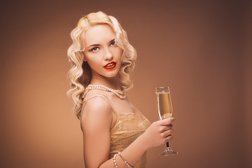 Vintage portrait of a girl with champagne. Blonde in studio.