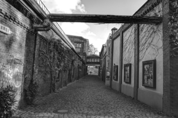 Looking down a long dark back alley HDR black and white