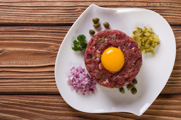tartare with egg, capers and cucumbers close-up top view