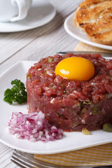 beef tartare with egg and vegetables closeup.  Vertical