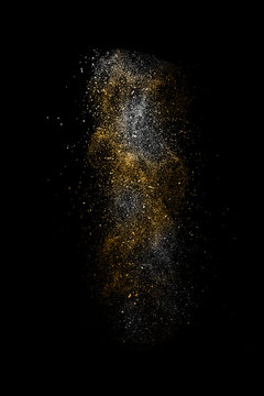 Stop motion of white and orange dust explosion isolated on black