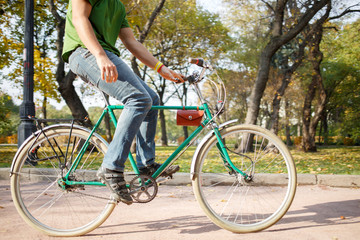 Close-up of young man riding bicycle in park
