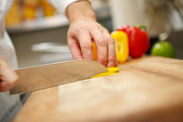 Obraz na płótnie Canvas man's hands cutting pepper. Salad preparation