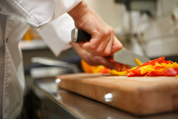 closeup on hands cutting yellow pepper