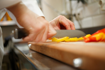 closeup on hands cutting yellow pepper
