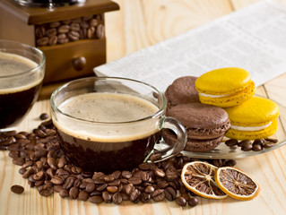 Coffee cup with macaroon and newspaper