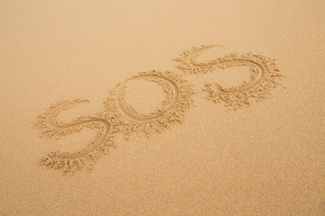 SOS - Inscription on the sand of tropical beach