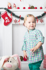 Cute little girl standing near  New Year  Christmas fireplace