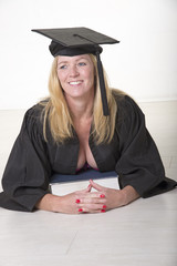 Female mature university student wearing cap and gown