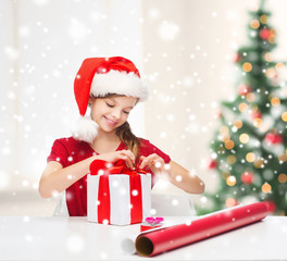 smiling girl in santa helper hat with gift box