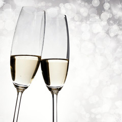 Toasting with champagne glasses on sparkling holiday background