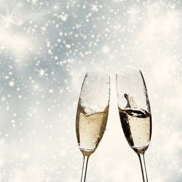 Toasting with champagne glasses on sparkling holiday background