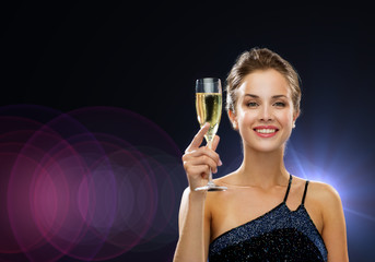 smiling woman holding glass of sparkling wine