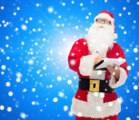 man in costume of santa claus with notepad