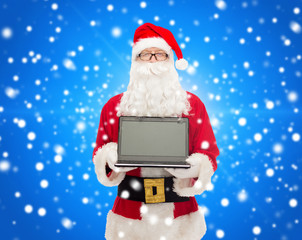 man in costume of santa claus with laptop