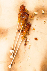 three sugar sticks on old medieval paper background