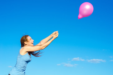 happy smiling woman arms raised with flying air balloon