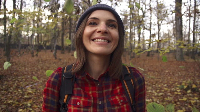 Happy woman enjoying falling leaves in forest, super slow motion