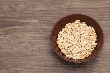 A white ceramic bowl full of Seeds over old wood background