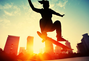 woman skateboarder skateboarding at sunrise city © lzf