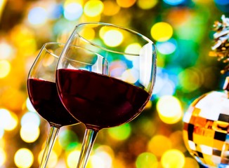 red wine glasses on colorful bokeh and disco ball background