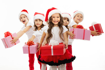 Group of happy kids in Christmas hat with presents