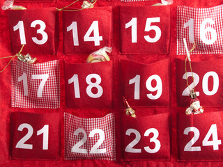 roter adventskalender mit klein spielzeuge und süßigkeiten ab nummer 13 bis 24  freigestellt auf...